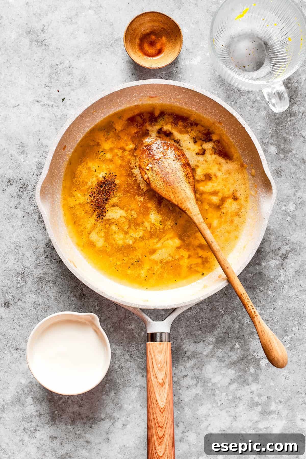 Smothered Chicken breasts feature pan-fried chicken in a crispy breadcrumb coating topped with a rich and creamy homemade gravy. Flour is whisked into butter and aromatics in a pan, cooking to form a golden roux.