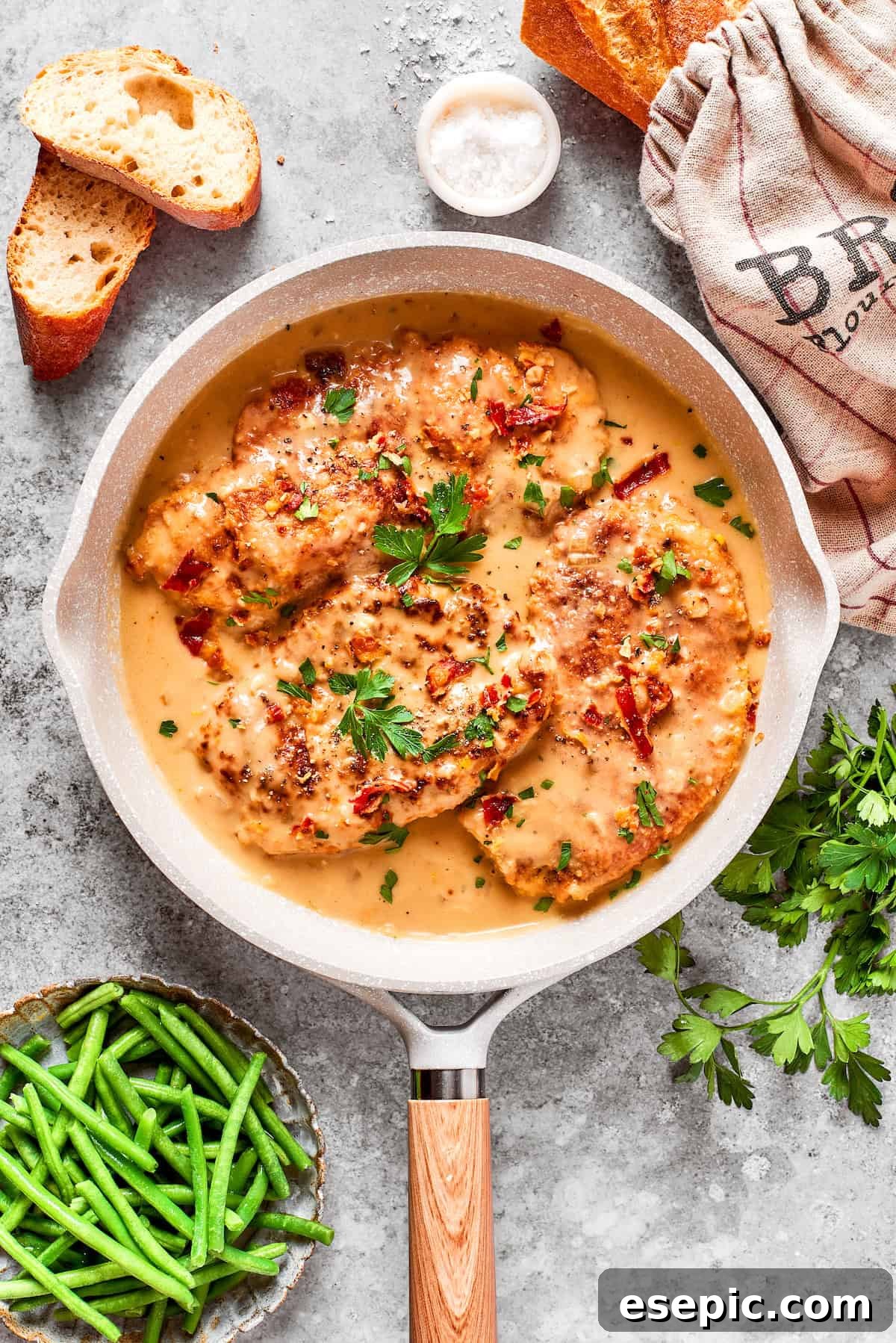 Smothered Chicken breasts feature pan-fried chicken in a crispy breadcrumb coating topped with a rich and creamy homemade gravy. A pan filled with beautifully smothered chicken breasts, submerged in a rich, creamy gravy, ready to be served.