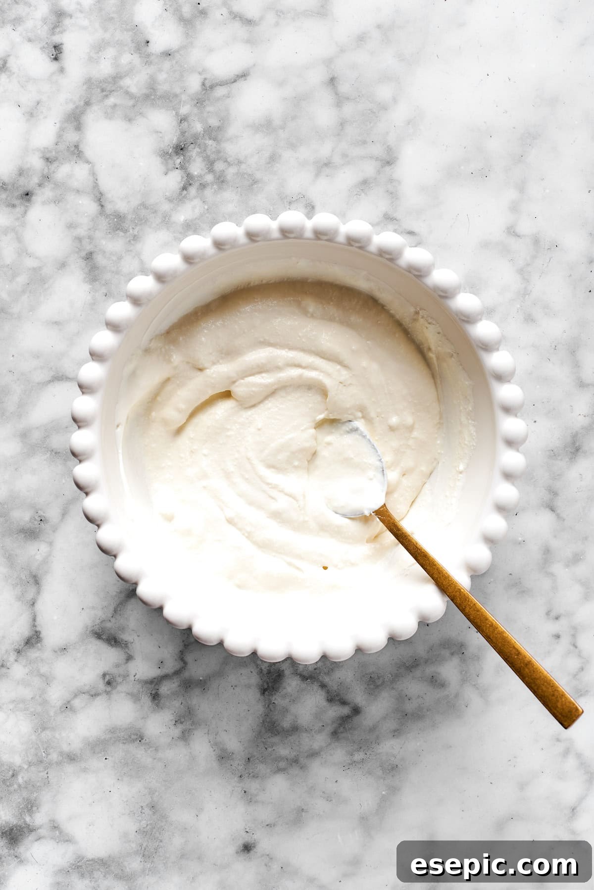 Smooth, blended cheese mixture in a white bowl, showing the desired creamy texture.