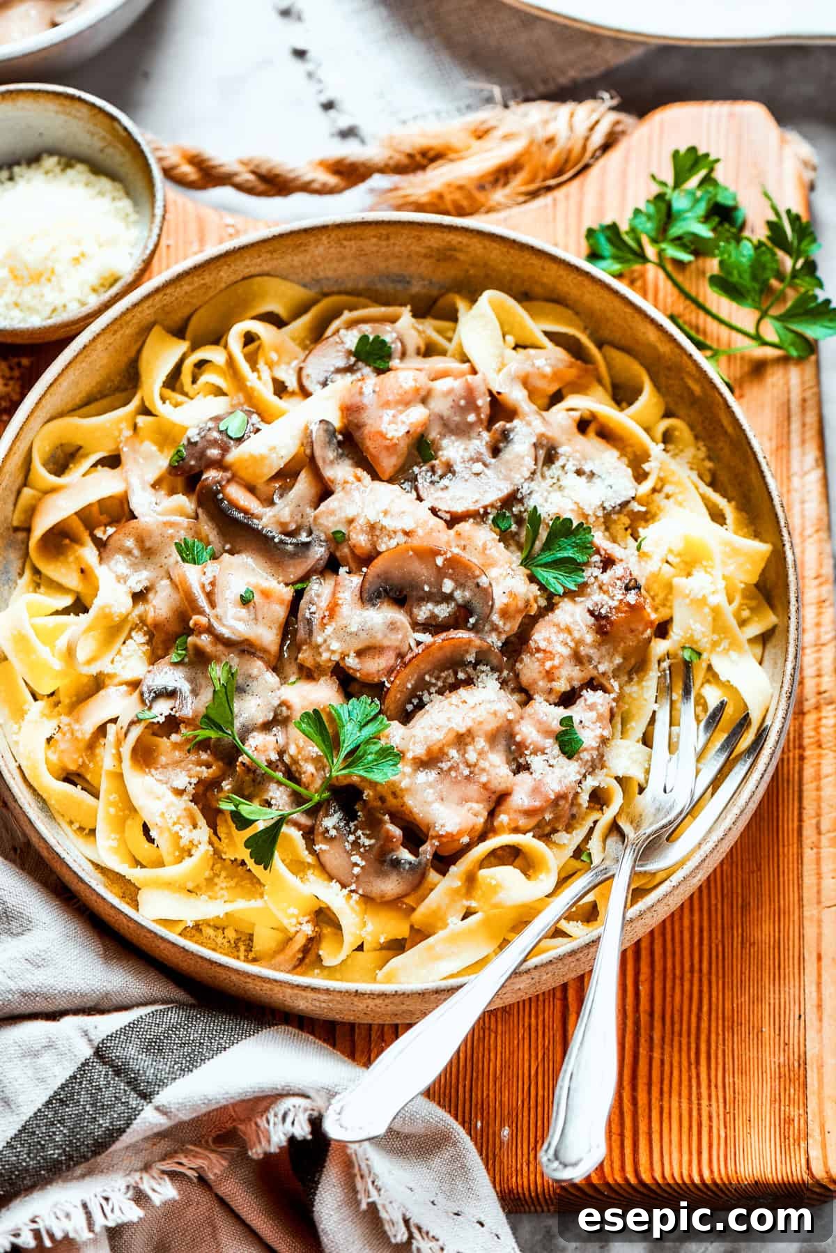 A beautifully plated dish of creamy chicken Marsala fettuccine on a cutting board, ready to be served.
