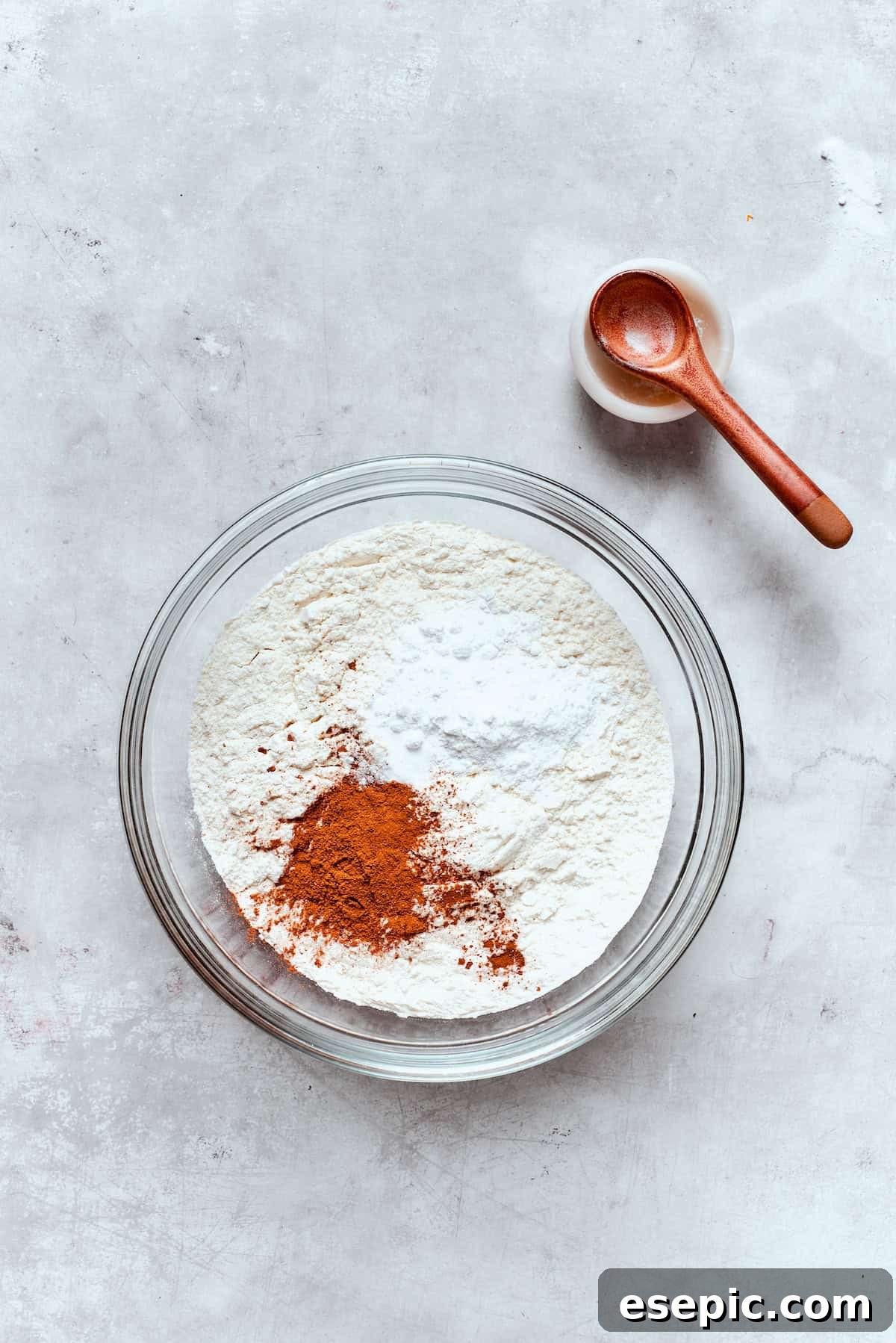 Baked not fried apple cider donuts are perfectly tender, dusted with spiced sugar, and fragrant with sweet apple cider. A separate bowl holds all the dry ingredients, including flour, baking powder, baking soda, salt, and spices, combined.