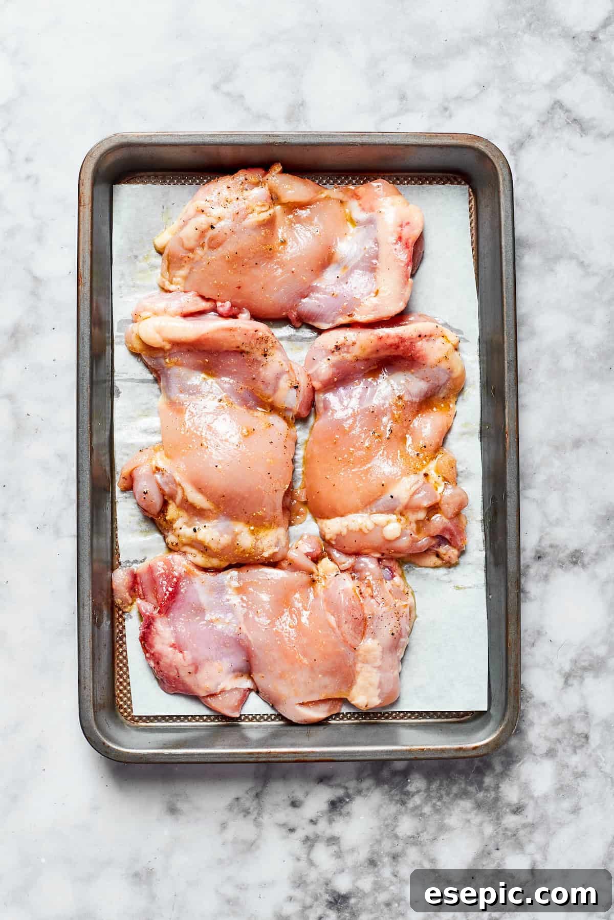 Creamy Garlic Parmesan Chicken Pasta 5 Raw chicken seasoned and arranged on a baking sheet, ready for roasting to golden perfection.