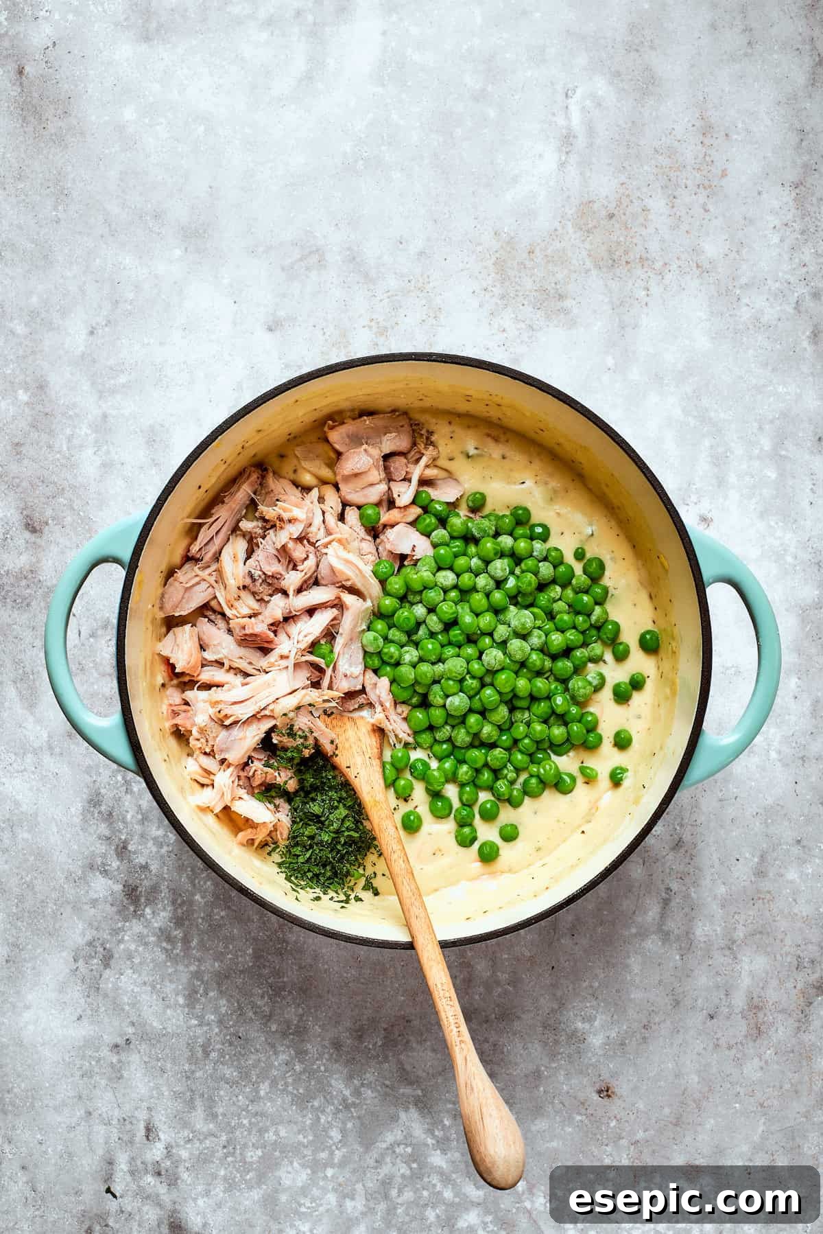 Chicken pot pie casserole is everything you love about the classic comfort food, baked under fluffy buttermilk biscuits instead of pie crust! Stirring shredded cooked chicken and frozen peas into the creamy pot pie filling in a large pot.