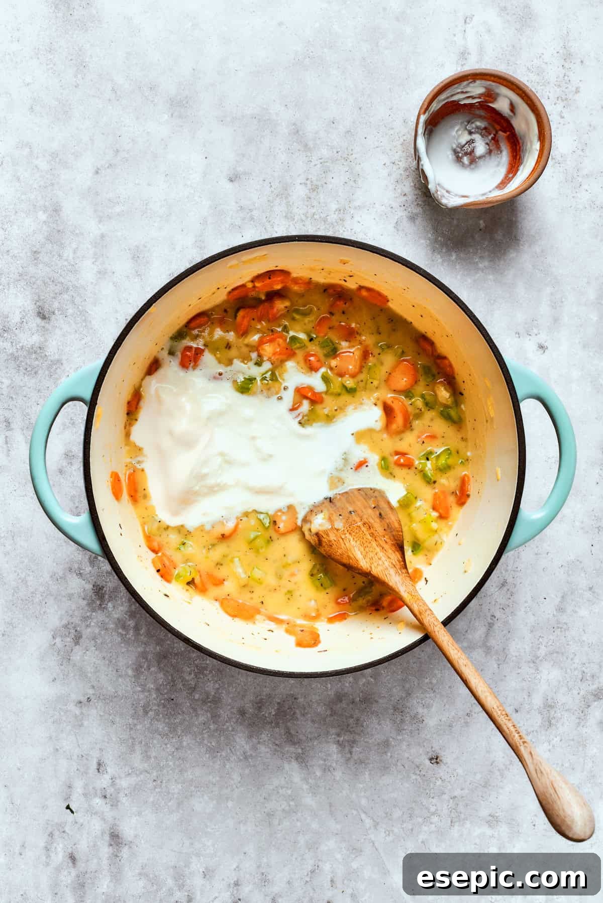 Chicken pot pie casserole is everything you love about the classic comfort food, baked under fluffy buttermilk biscuits instead of pie crust! Stirring half and half into the simmering pot pie filling, making it rich and creamy.