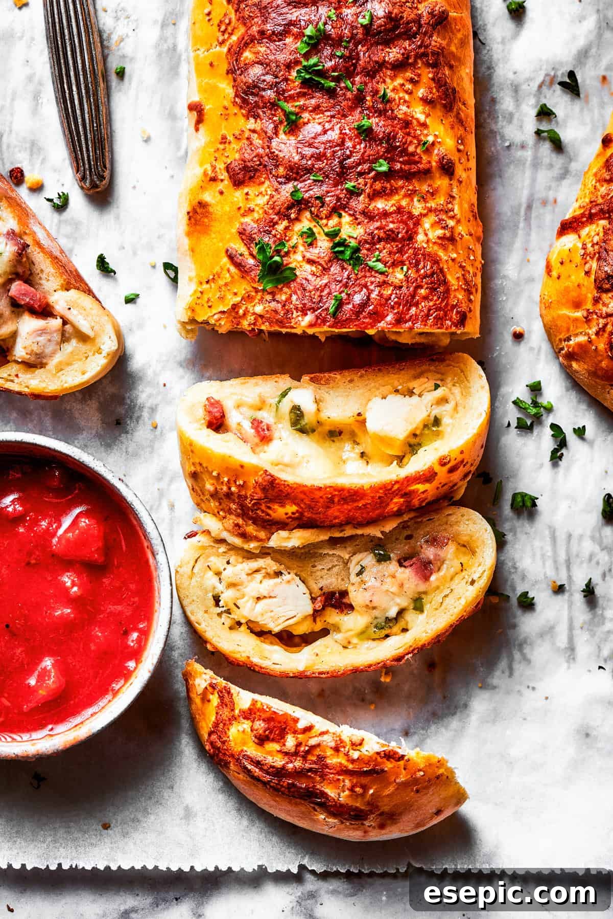 A sliced Costco chicken bake and a bowl of sauce.