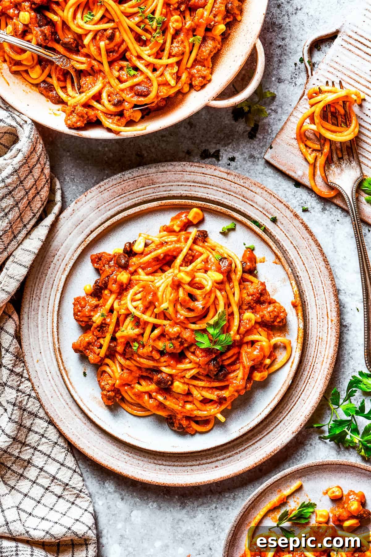 Two plates of Mexican spaghetti served with fresh garnishes, ready for a delicious dinner.