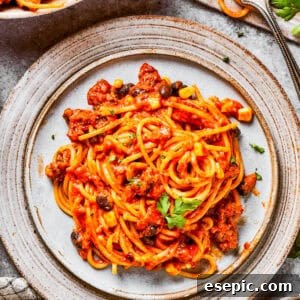Taco spaghetti on a plate, garnished with fresh toppings.
