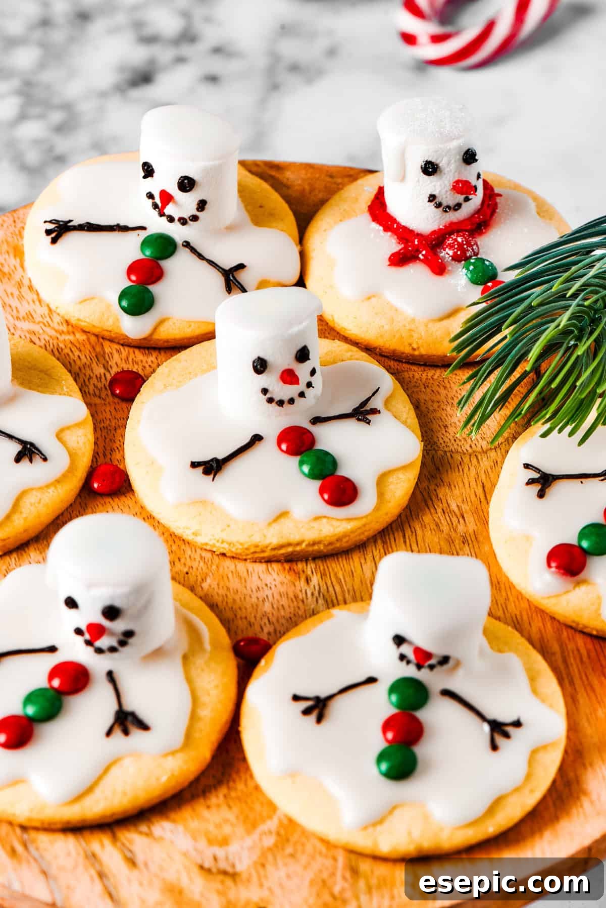 A charming display of completed melted snowman cookies arranged neatly on a rustic wooden tray.