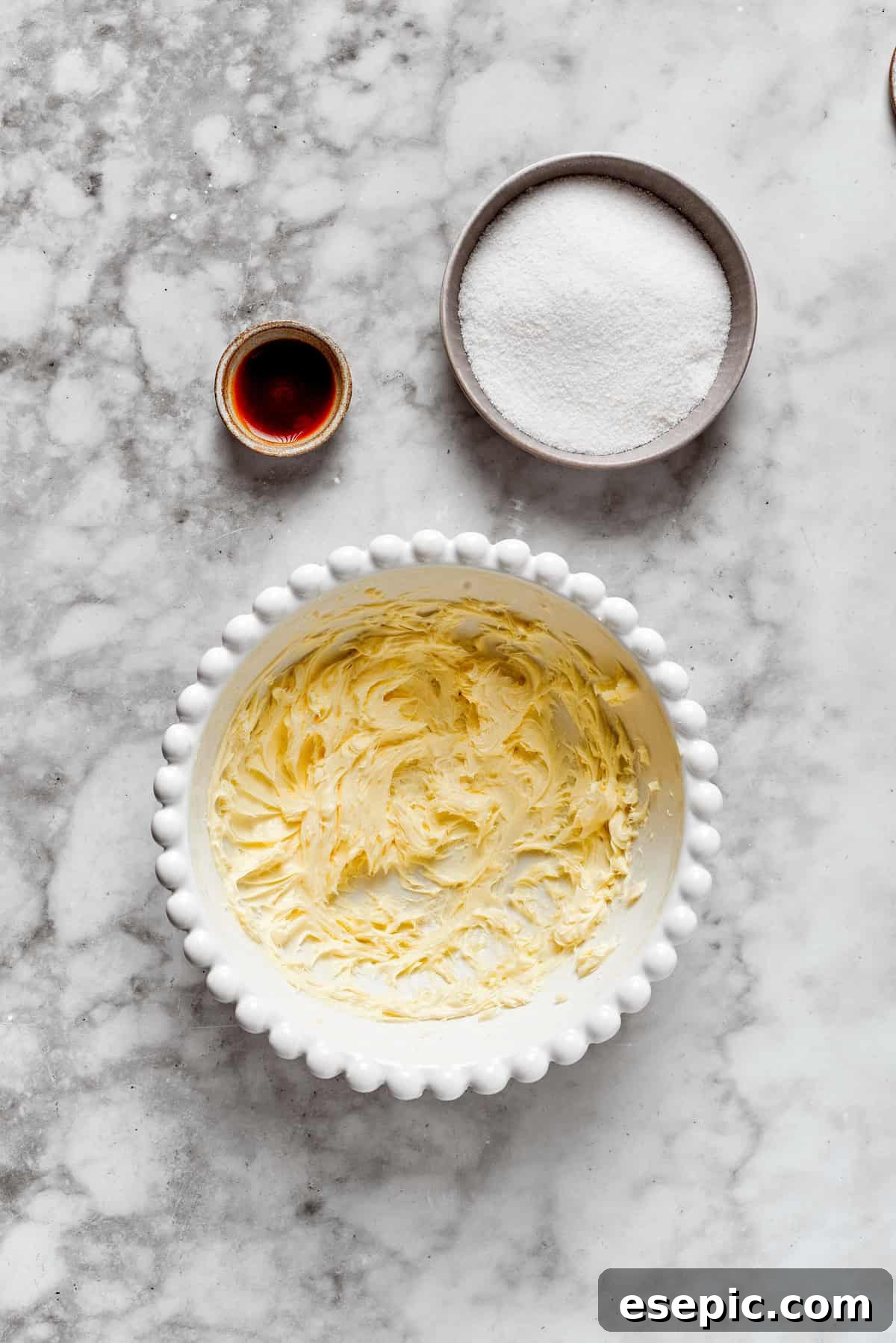 Creaming butter and sugar together in a mixing bowl, creating a light and fluffy base for cookies.