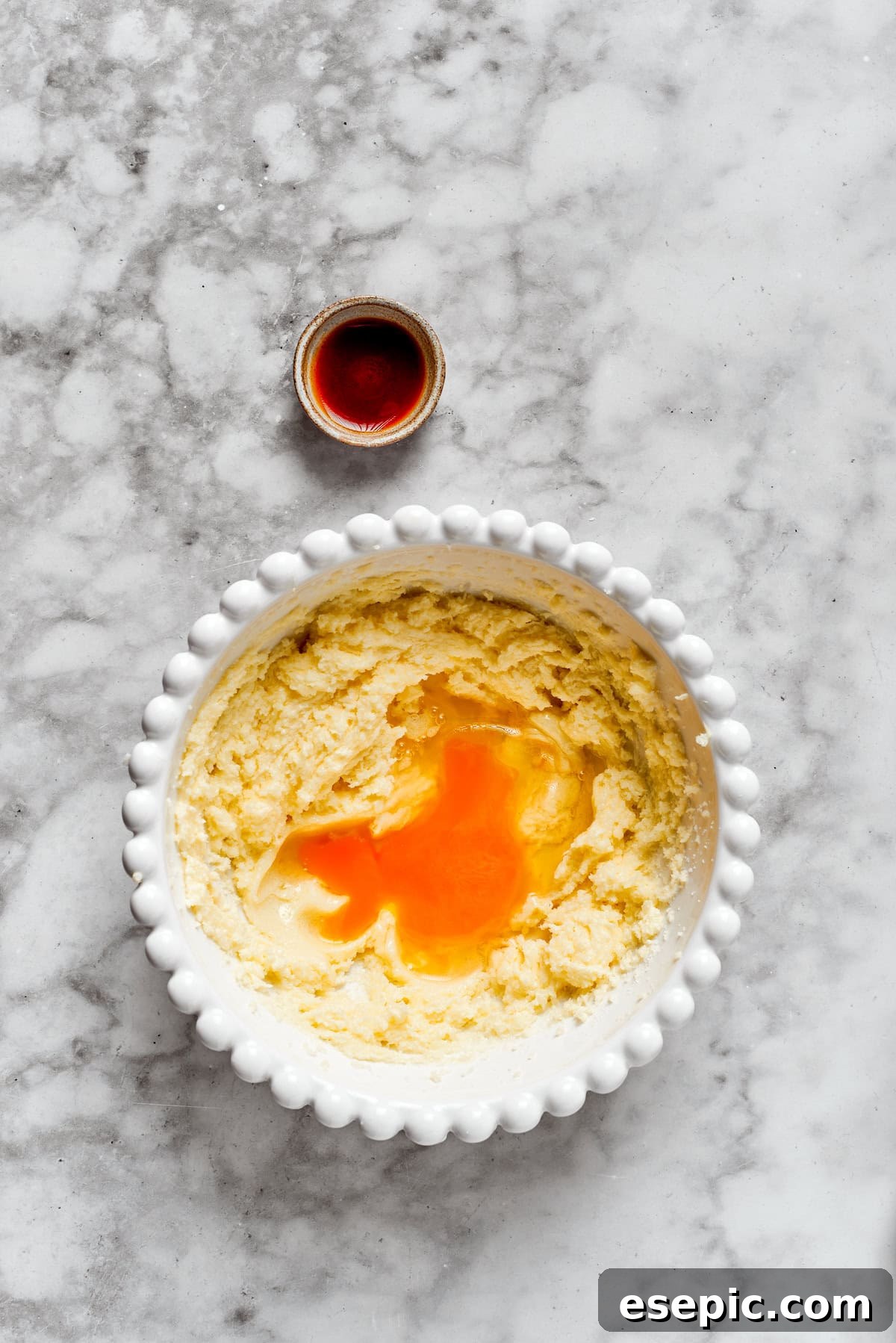 Adding eggs to the creamed butter and sugar mixture, essential for binding the cookie dough.