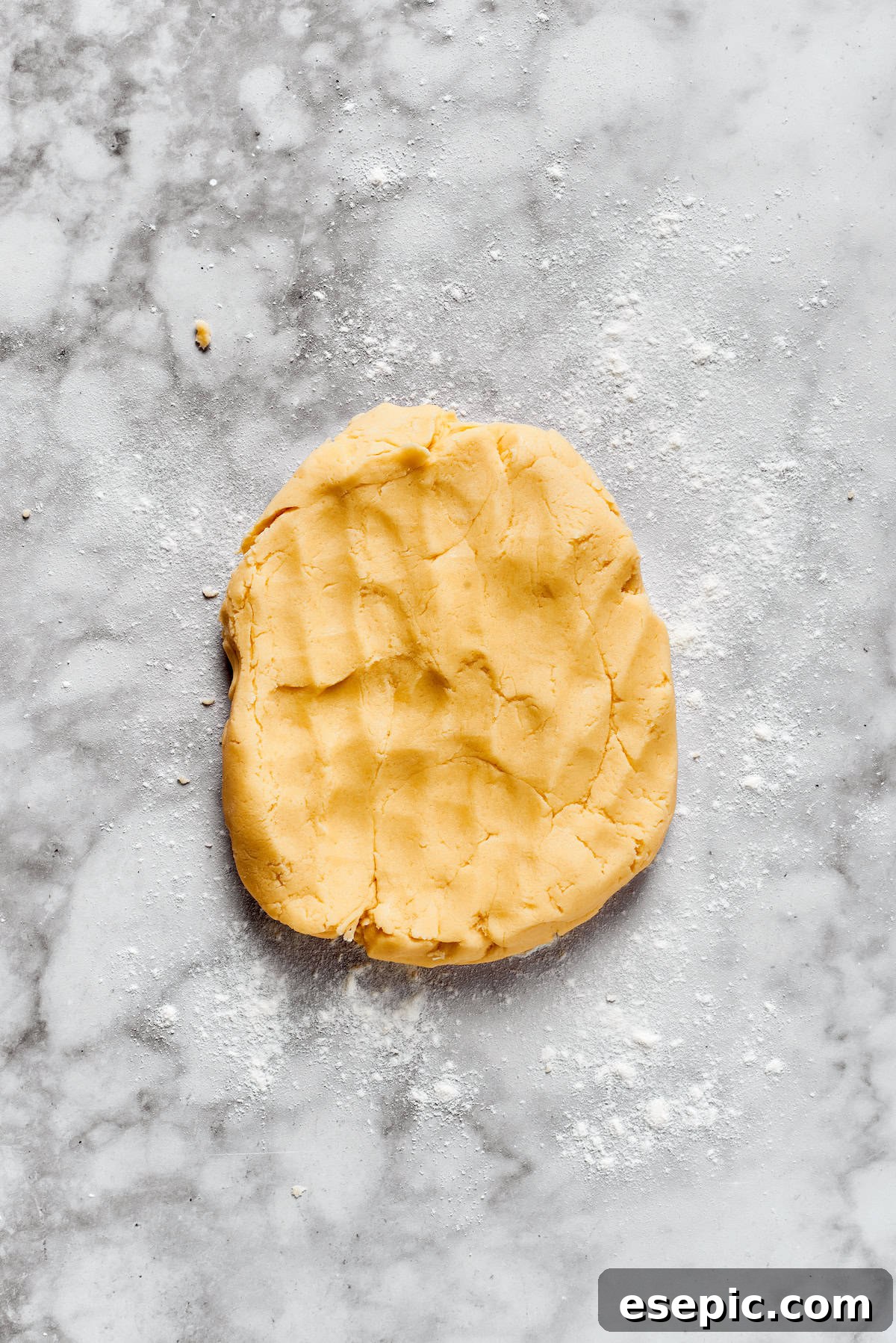 Prepared sugar cookie dough resting on a kitchen counter, ready to be rolled out.