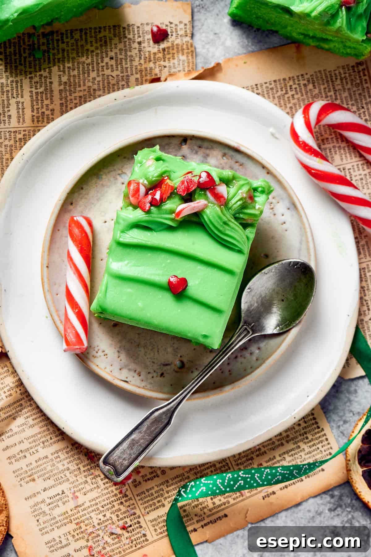 A plate with a slice of grinch cake and a spoon, perfectly poised for enjoyment.