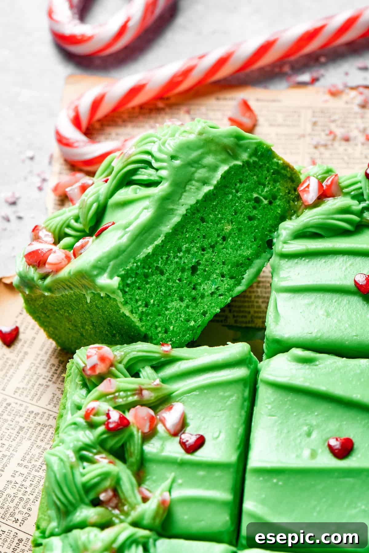 A slice of green cake turned on its side, showcasing its moist texture and vibrant color.