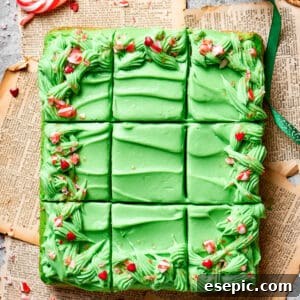 A grinch cake is cut into 12 pieces, showcasing its vibrant green layers and festive decorations.