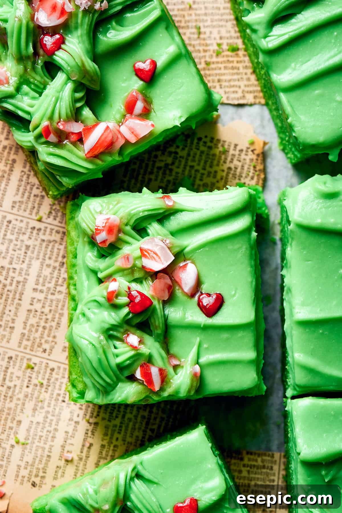 Crushed candy tops slices of grinch cake, adding a festive and colorful touch to the dessert.