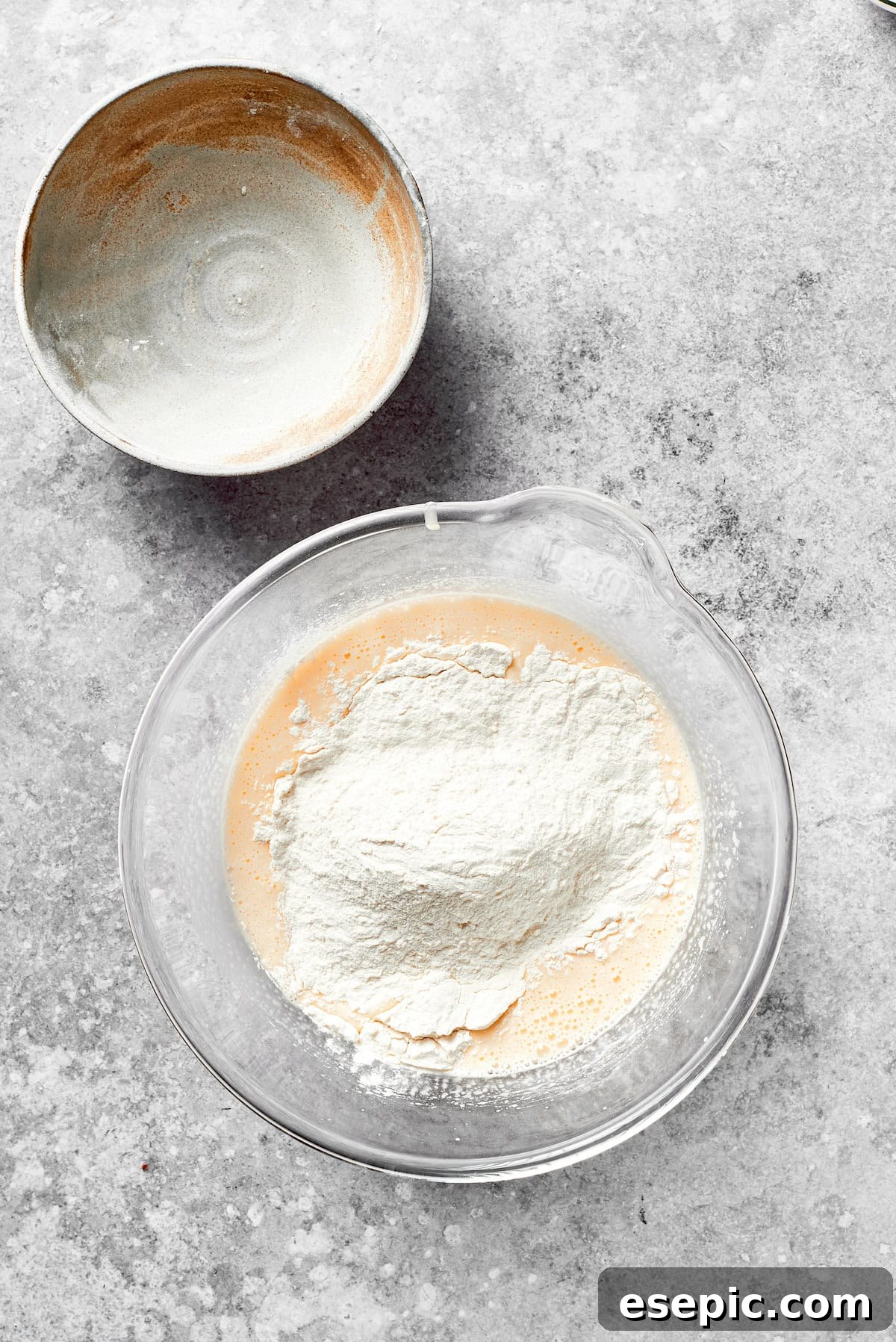 Dry ingredients being gently folded into the green grinch cake batter.
