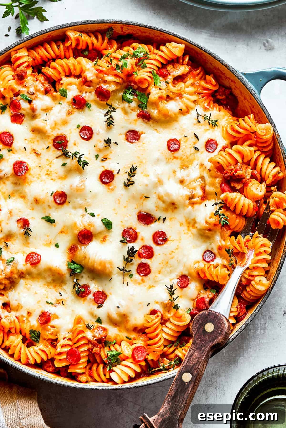 A big pan of pizza pasta topped with melted cheese and pepperoni, ready to be served.