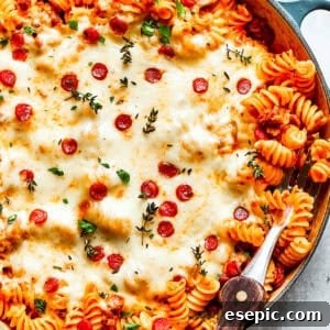 A big pan of pizza pasta topped with melted cheese and pepperoni.