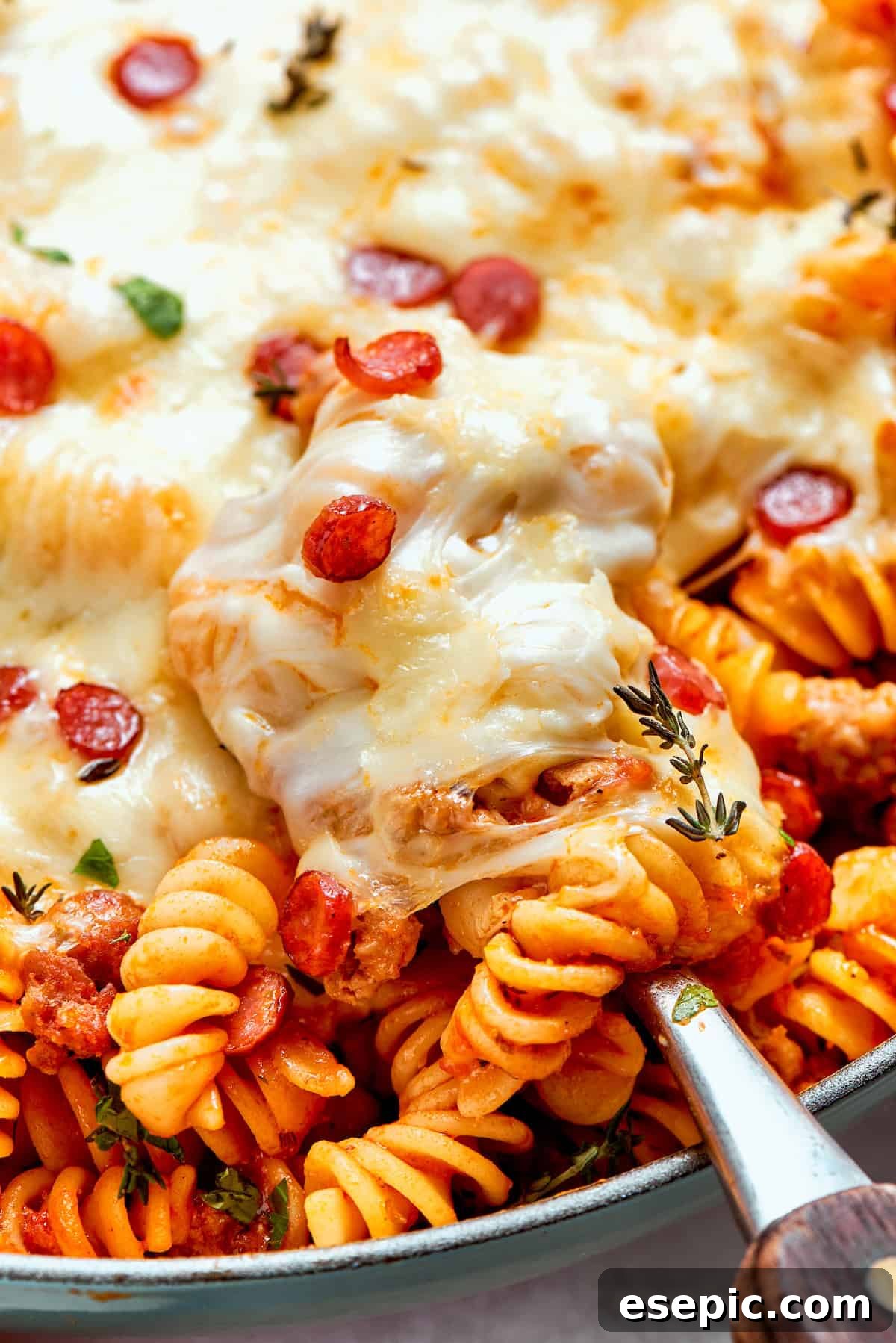 Close-up of melted cheese on a pan of pizza pasta, showing a beautiful golden-brown crust.