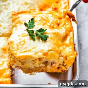 Scooping out a slice of casserole from the baking dish.