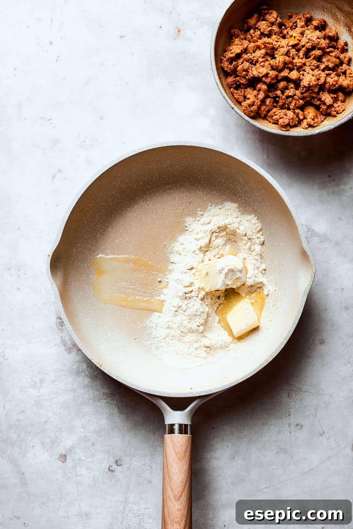 Melted butter and flour added to a hot skillet, beginning to form a roux.