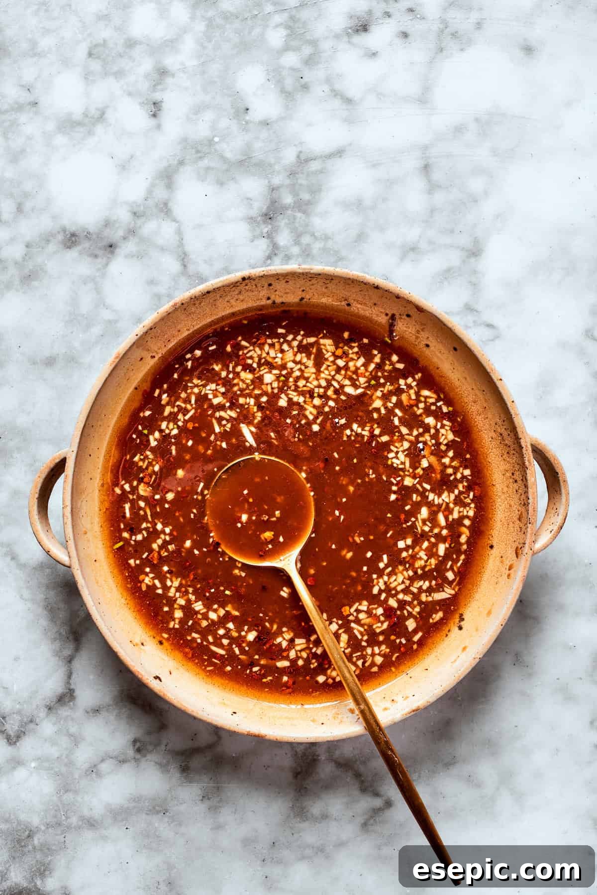 My teriyaki salmon recipe glazes flaky salmon with a homemade sticky-sweet marinade that adds tons of flavor. A spoon coated in thick, glossy teriyaki sauce demonstrates its perfect consistency after cooking.