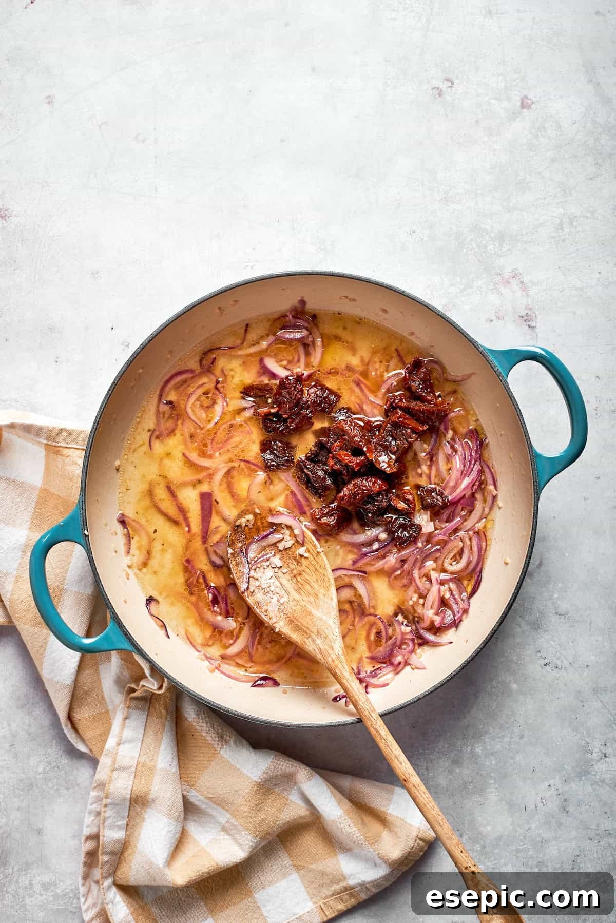 Cheesy, marry me chicken pasta features tender bites of chicken swirled in a creamy sauce along with sundried tomatoes and pasta. Sundried tomatoes are stirred into a skillet.