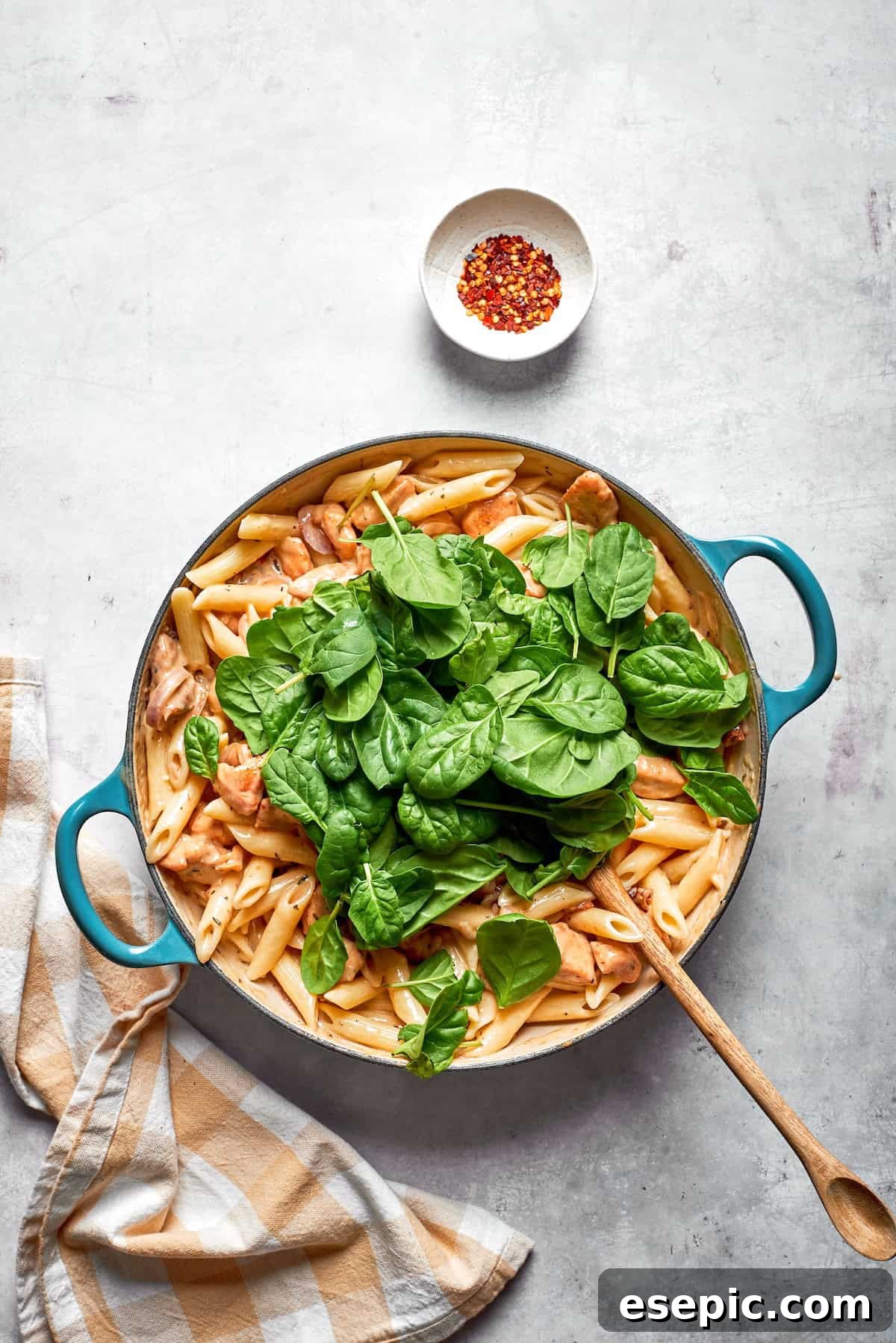Irresistible Chicken Pasta 3 Spinach leaves added to a skillet of marry me chicken pasta.