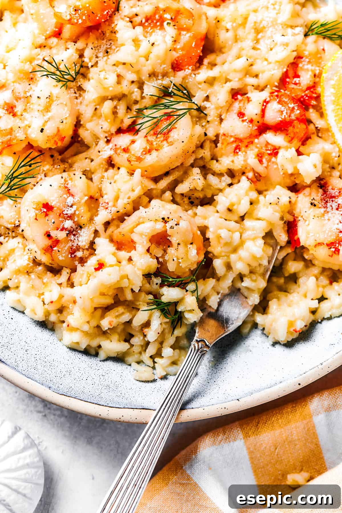 A close-up of creamy shrimp risotto being served on a white plate, highlighting the tender rice and pink shrimp.