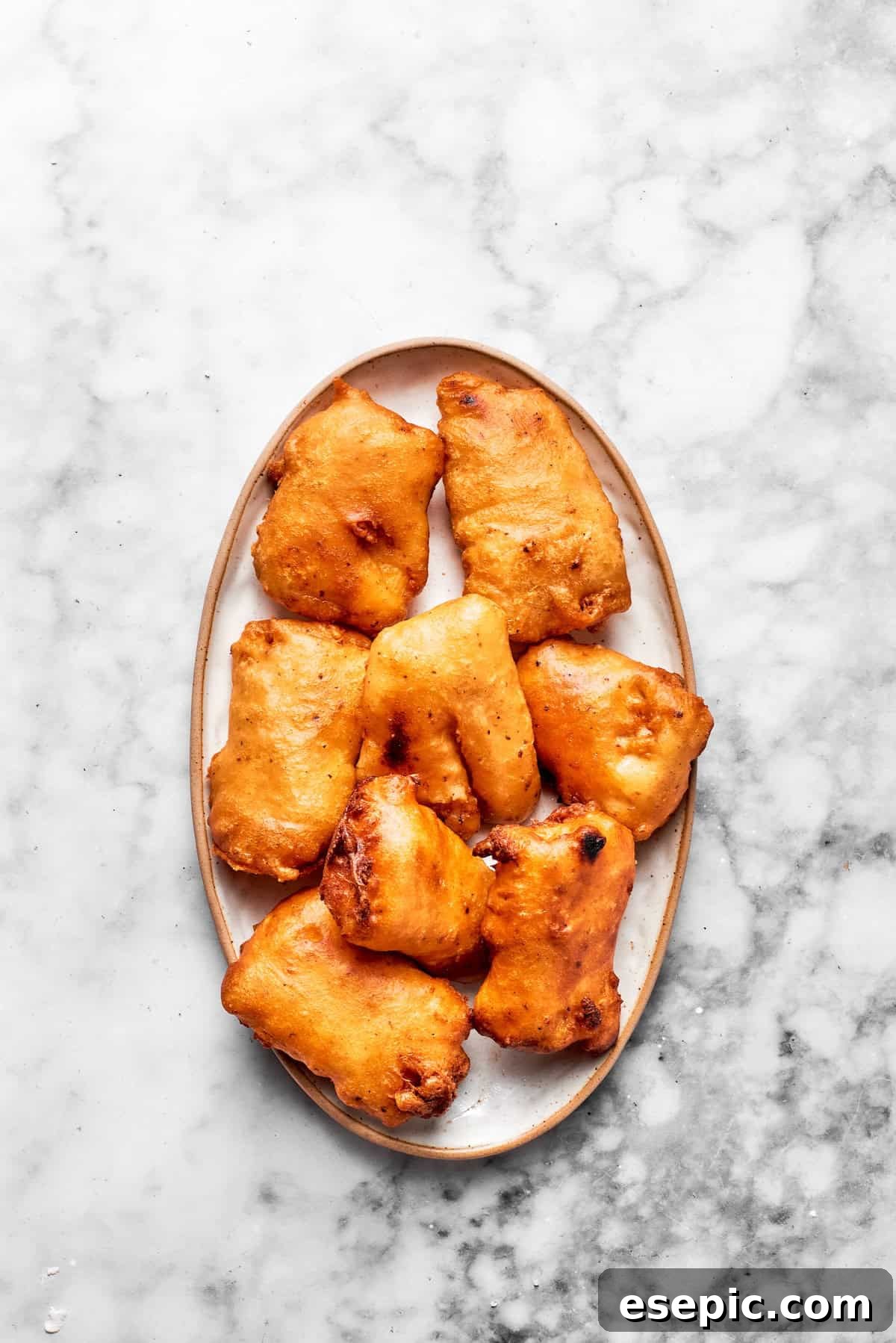 Fried pieces of fish on a plate for a fish sandwich.