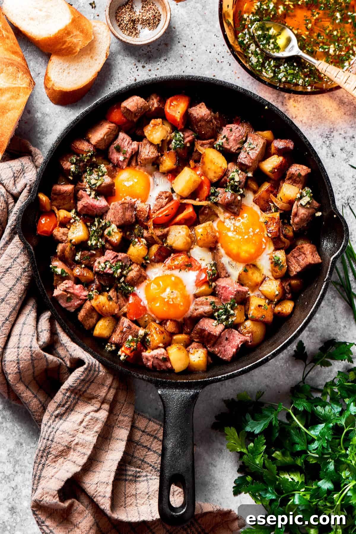 Fried eggs top a skillet of steak and eggs, ready to be served.