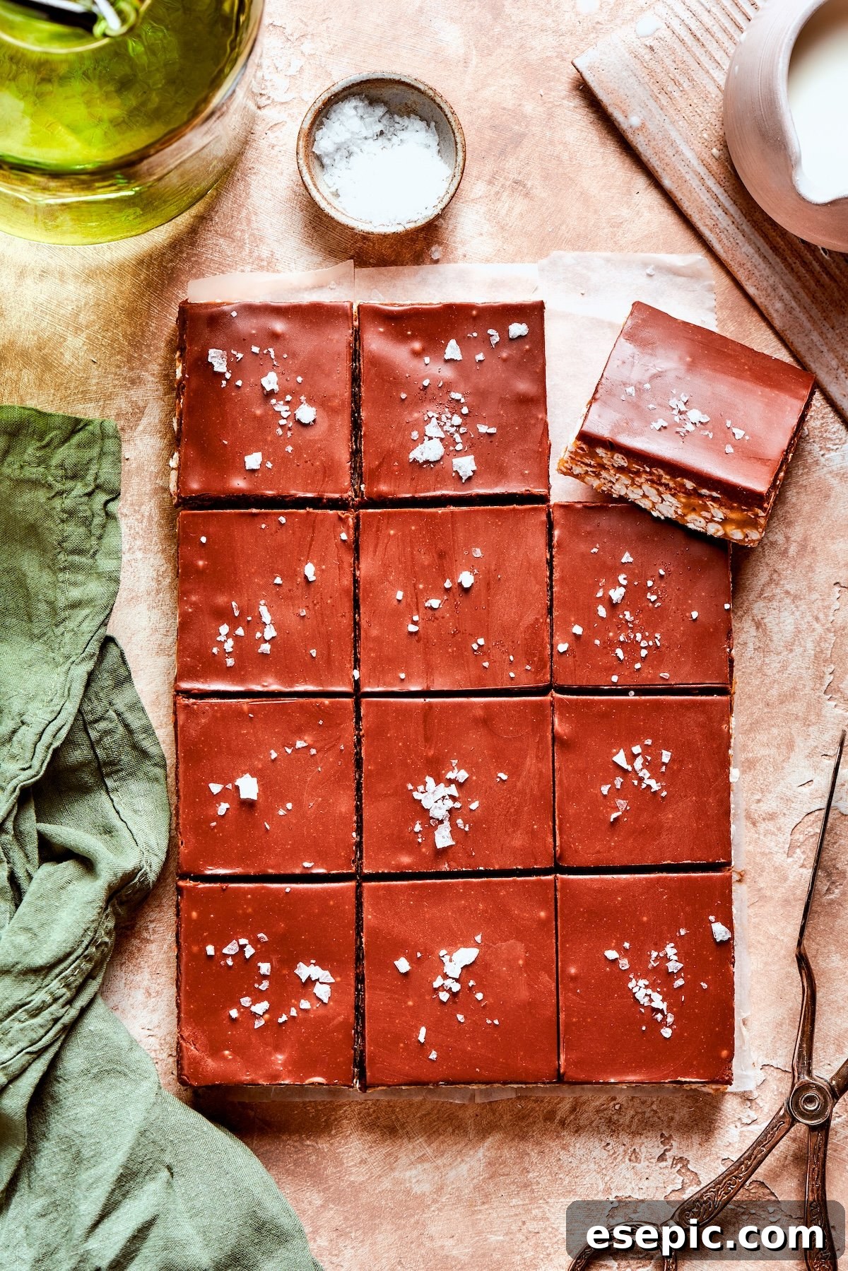 No-bake scotcharoos feature creamy peanut butter, crispy rice cereal, and a sweet layer of melted chocolate and butterscotch. Flaky salt is added to a dozen scotcharoos, enhancing their visual appeal.