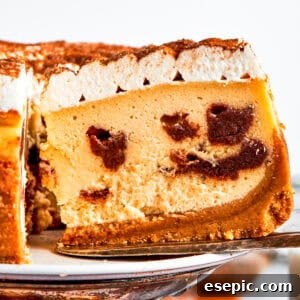A delectable slice of Cinnamon Roll Cheesecake, showing the creamy filling and swirled cinnamon.