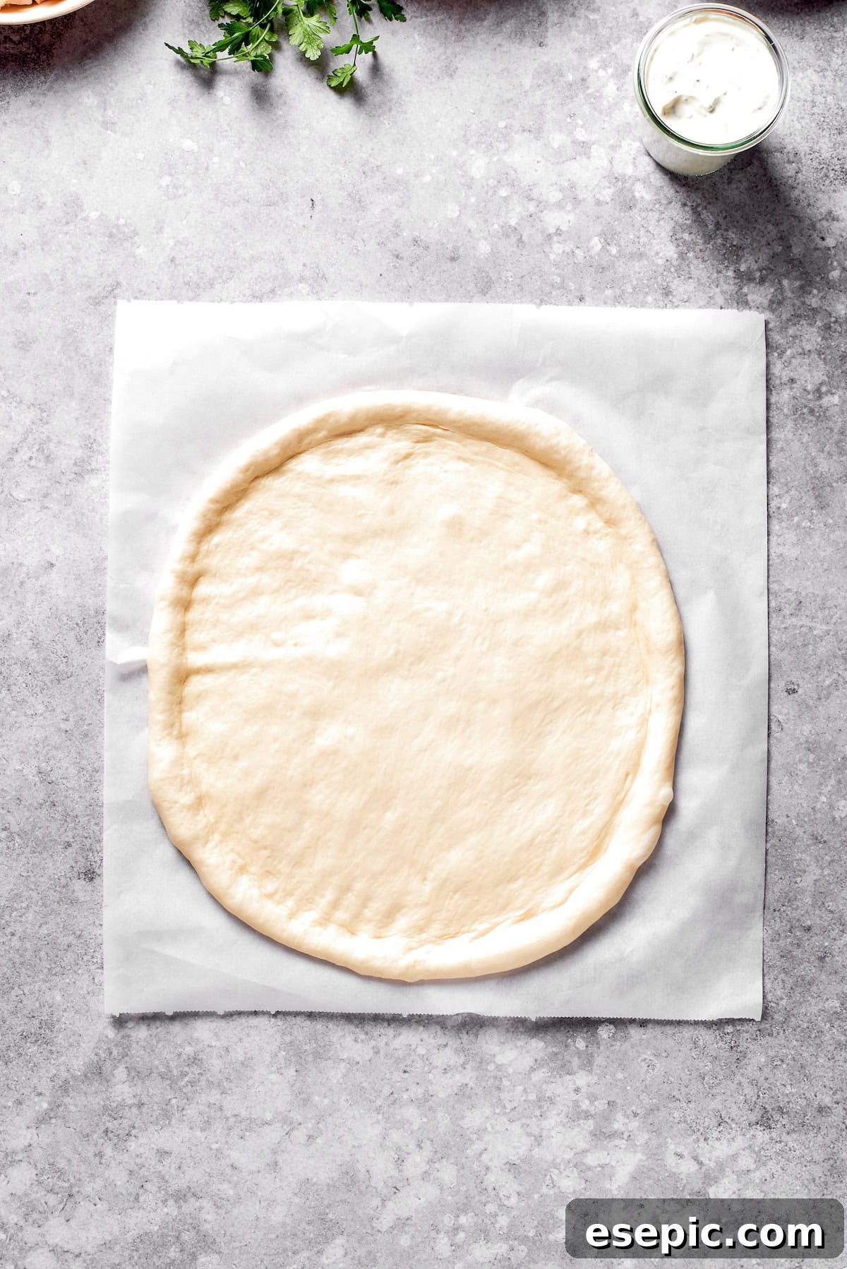 Pizza dough perfectly rolled out into a circular shape, ready for toppings.