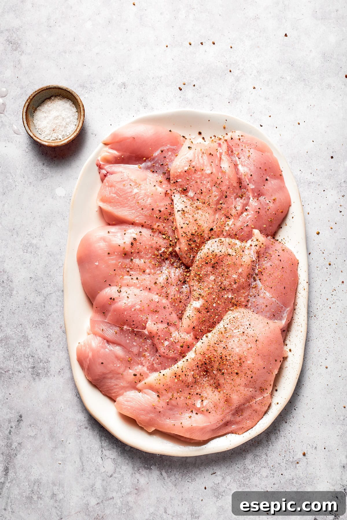 Chicken breasts after being pounded and seasoned with salt and pepper.