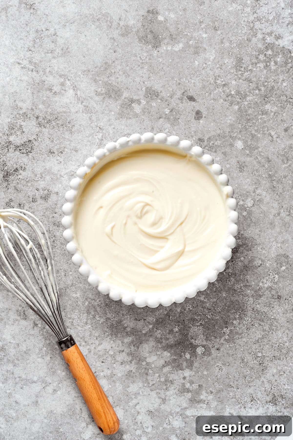 A bowl filled with a perfectly smooth cheesecake batter, ready for assembly.
