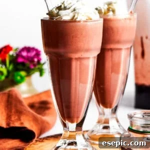 Chocolate milkshakes topped with whipped cream.