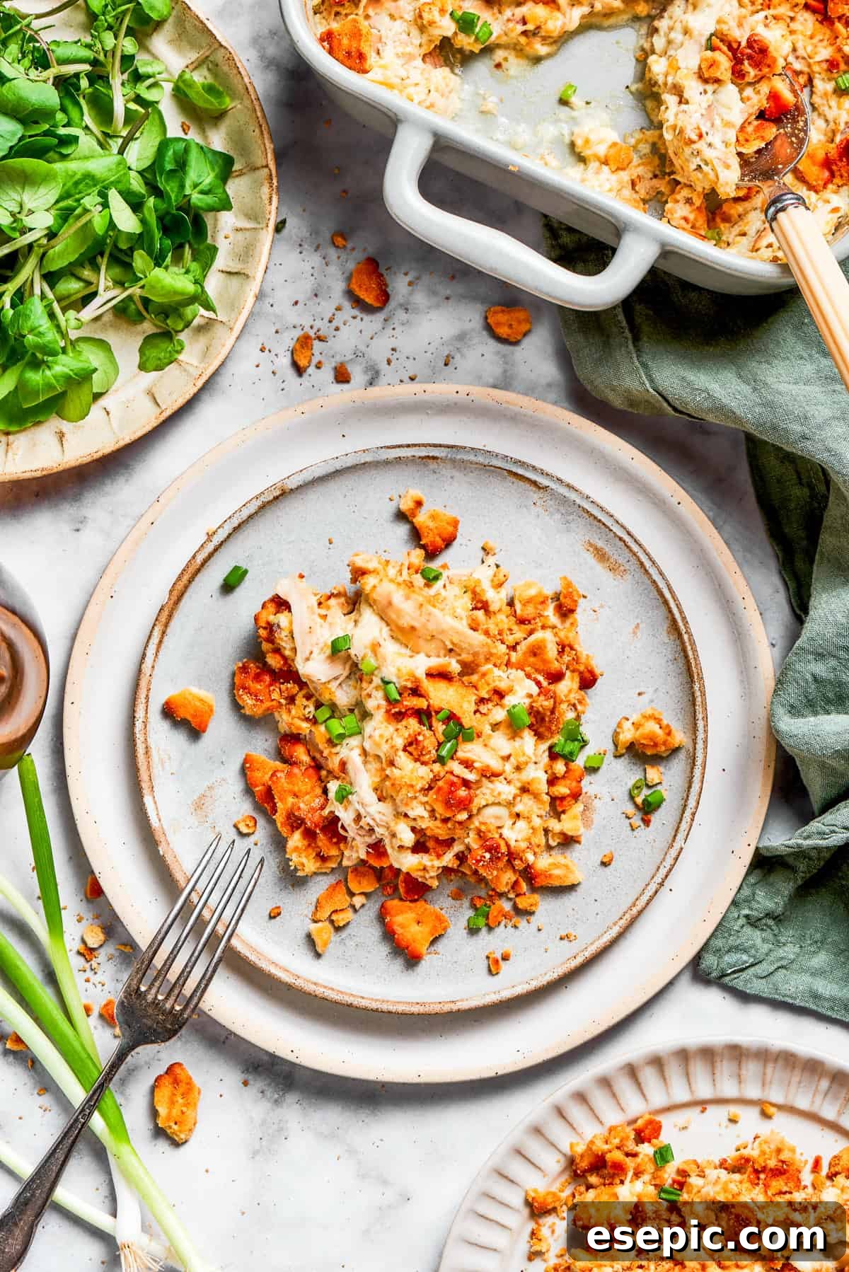 A generous serving of Million Dollar Chicken Casserole on a dinner plate, ready to be enjoyed with a fork.