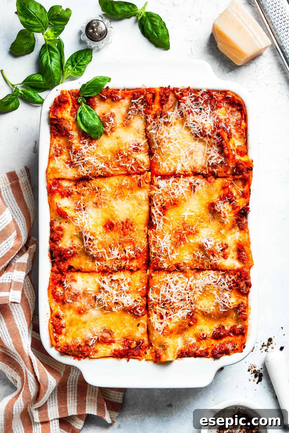 The best beef lasagna recipe is packed with tons of meaty, cheesy flavor and a rich and savory sauce. Make ahead friendly! A pan of beef lasagna cut into squares, showcasing its layers of pasta, meat sauce, and cheese.