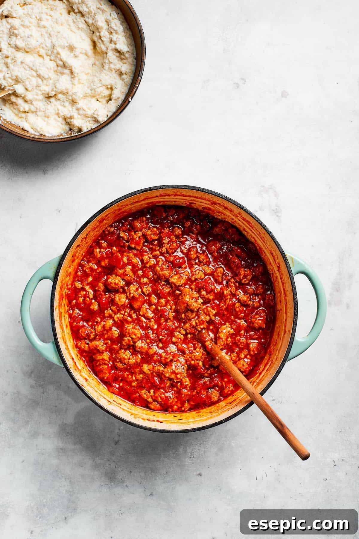 The best beef lasagna recipe is packed with tons of meaty, cheesy flavor and a rich and savory sauce. Make ahead friendly! A rich, red beef tomato sauce simmering gently in a large pot, indicative of deep flavor development.