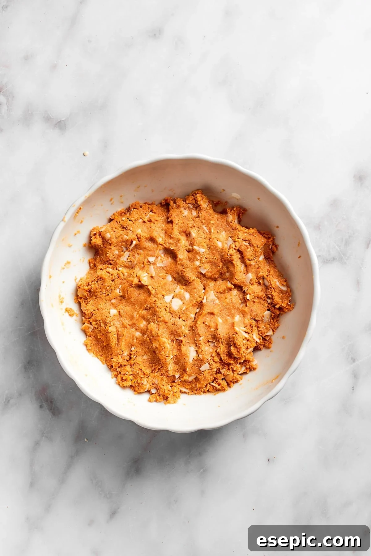 The lemon slice crust mixture, including condensed milk and milk, fully combined and ready to be pressed into the pan.
