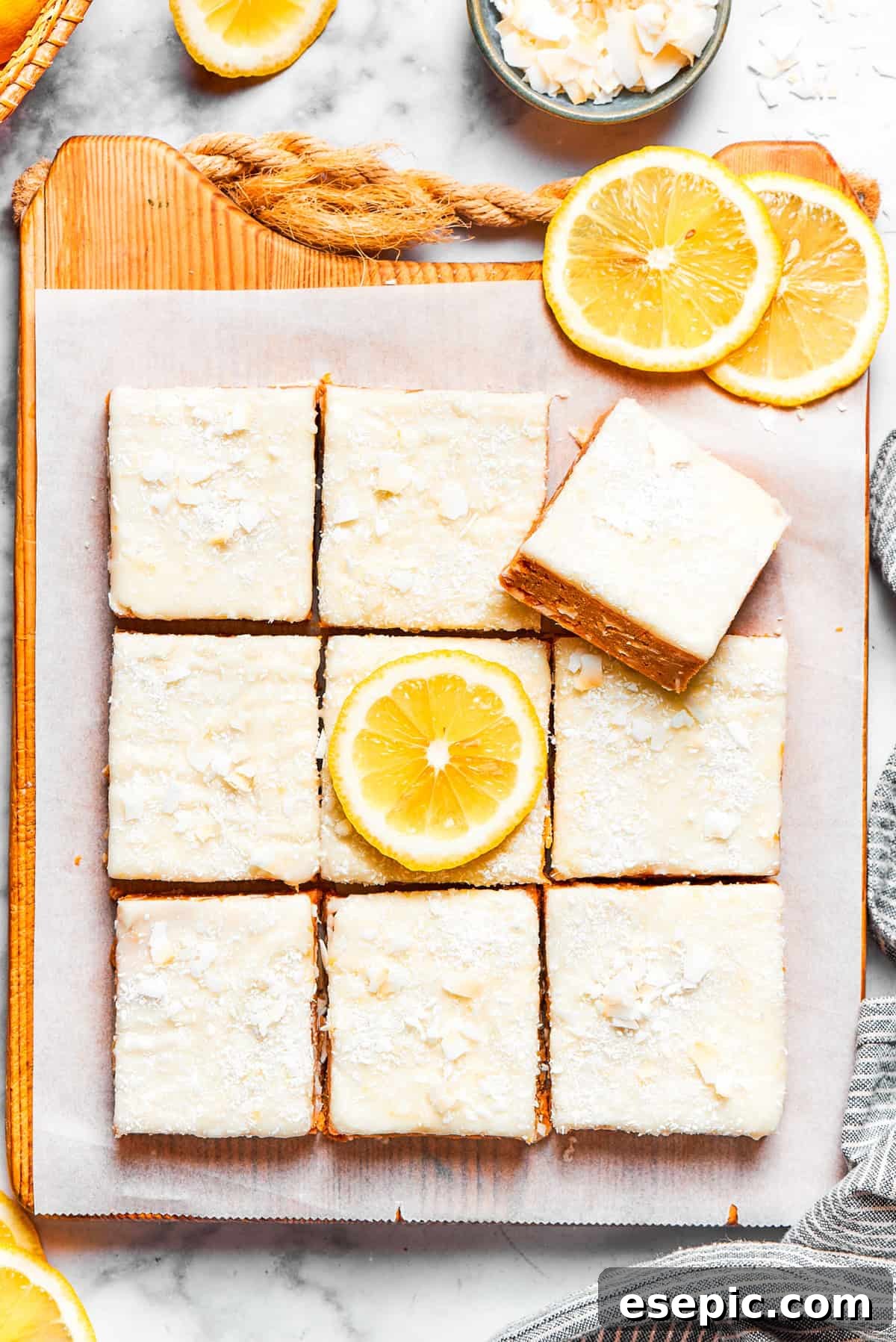 Squares of lemon slice topped with a generous layer of creamy frosting and sprinkled coconut.