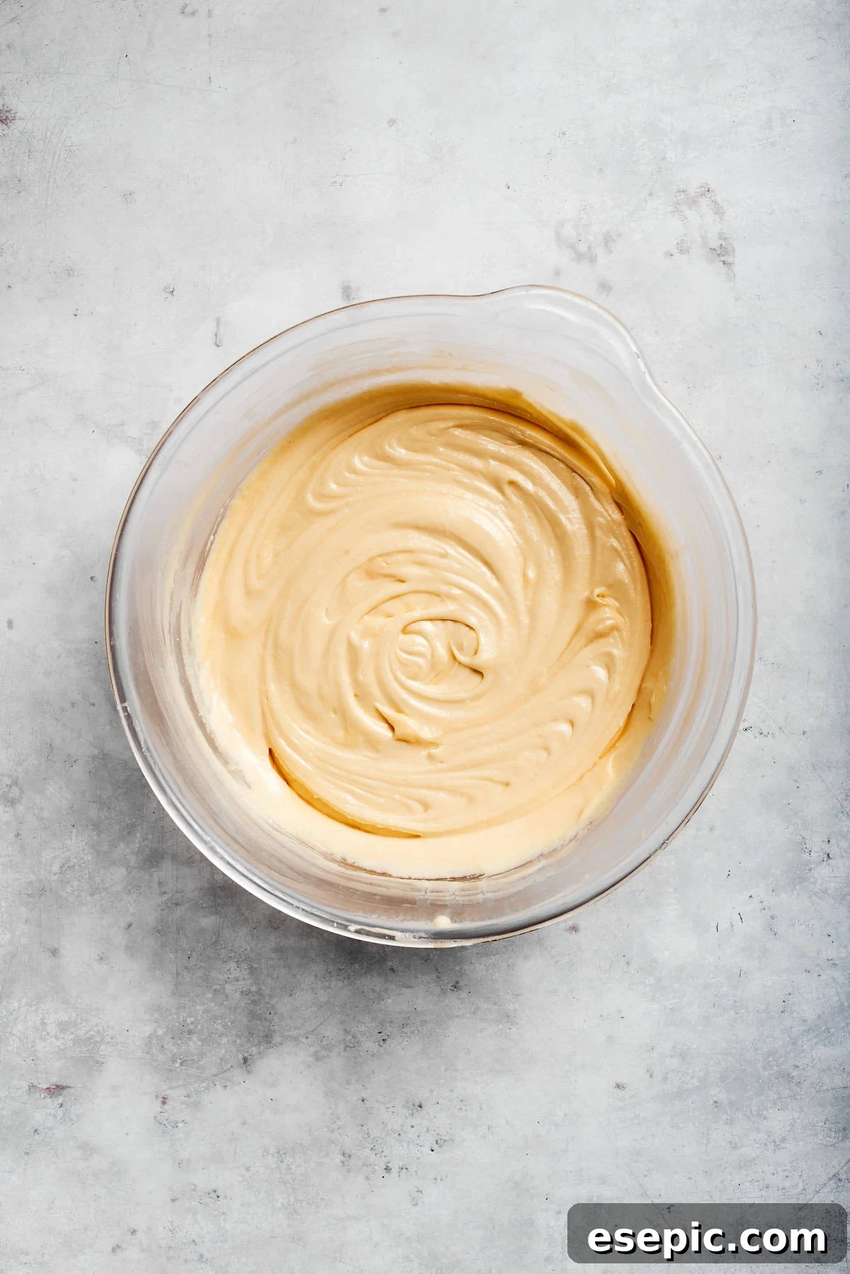 An easy recipe for Sock It To Me Cake, a tender coffee cake with a ribbon of brown sugar, cinnamon and toasted pecans through the center. Sock it to me cake batter in bowl.