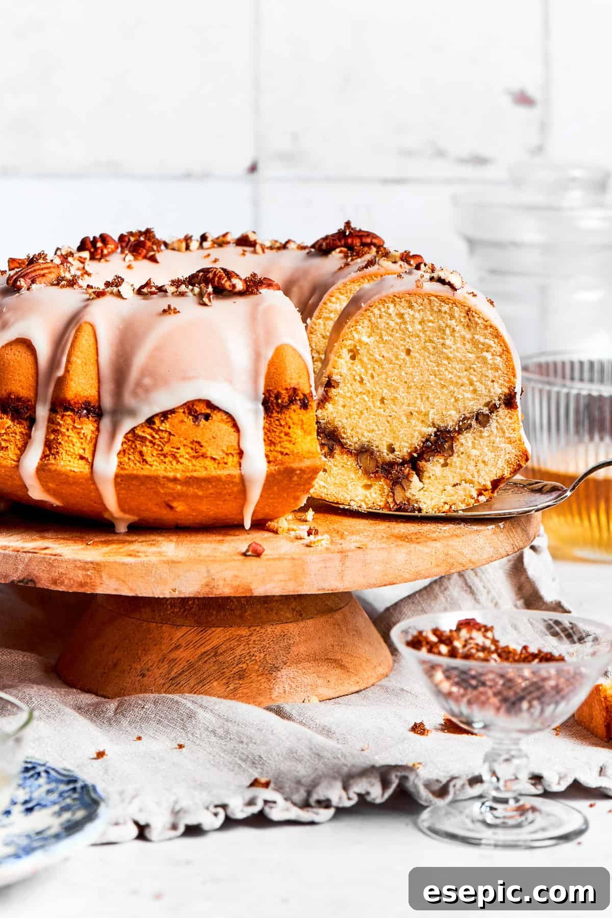 Glazed sock it to me cake on a plate, garnished with pecans.