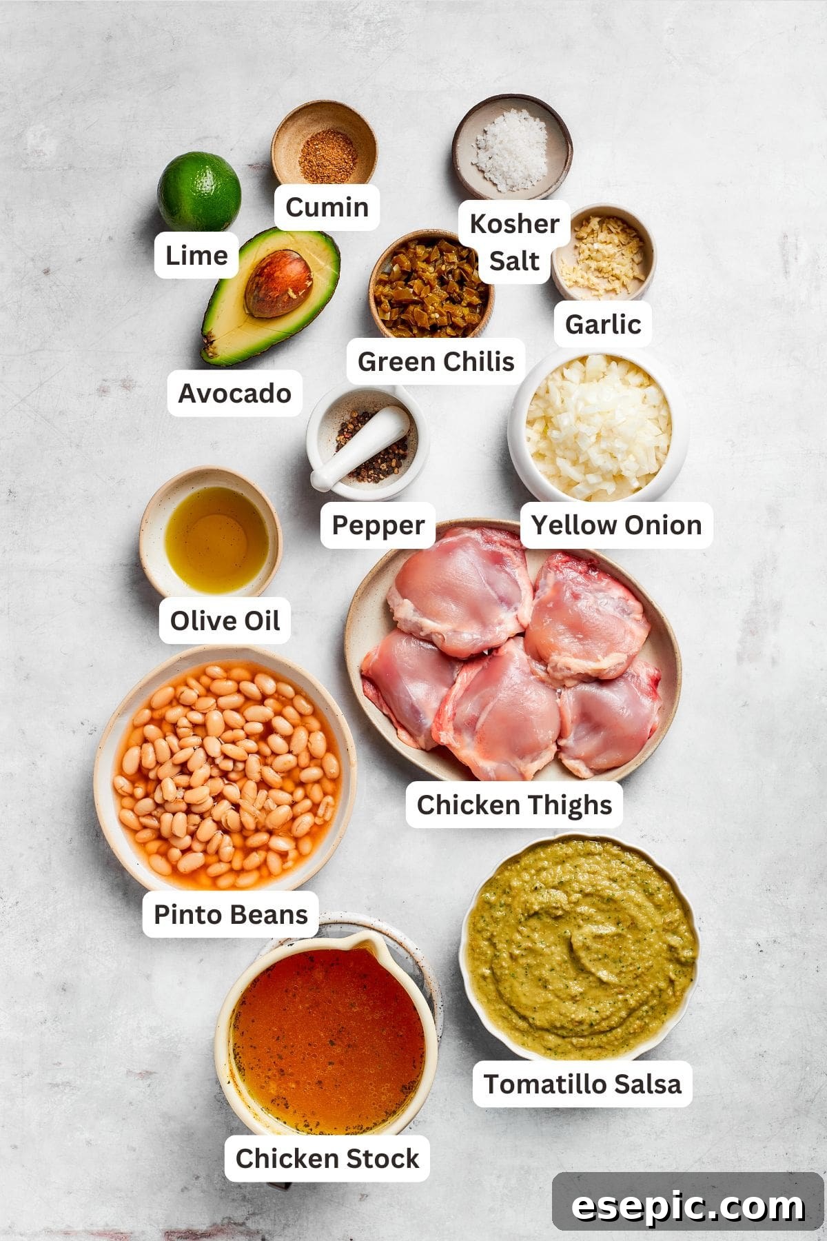 All the fresh and canned ingredients for spicy chicken soup are neatly arranged and clearly labeled on a countertop.