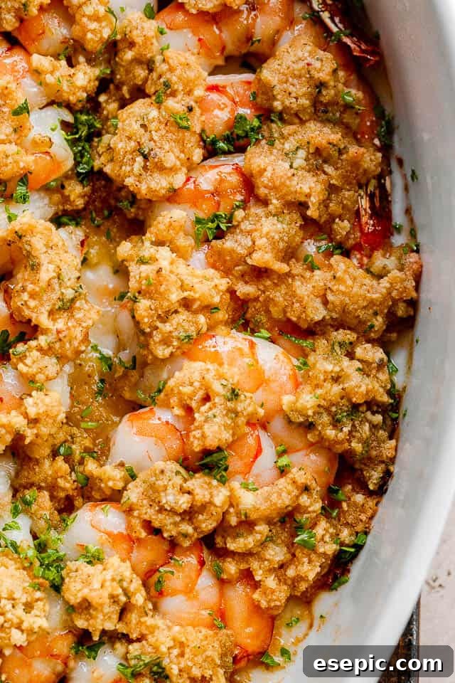close up shot of garlic butter baked shrimp in a white dish.