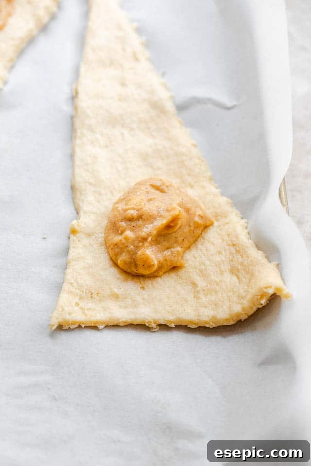 unrolled raw crescent dough with a dollop of pumpkin filling