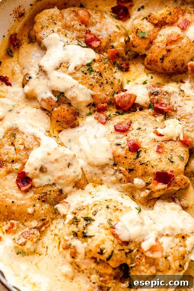 Creamy chicken thighs generously coated in a rich cheese sauce and topped with savory diced bacon, ready to be enjoyed.