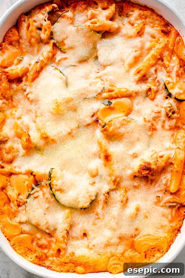 Velvety Zucchini Mushroom Pasta Bake 6 A top-down overhead shot of a cheesy covered baked pasta and zucchini casserole, showcasing the golden-brown crust and bubbling cheese.