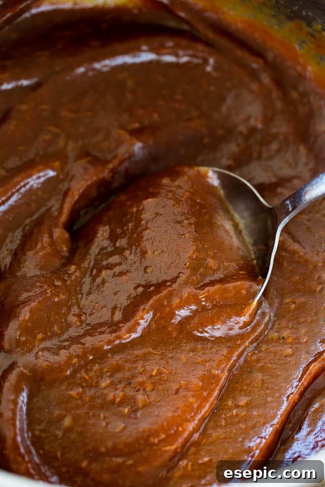 Velvety Smooth Instant Pot Apple Butter 3 Close-up shot of a silver spoon mixing through smooth, rich Instant Pot Apple Butter